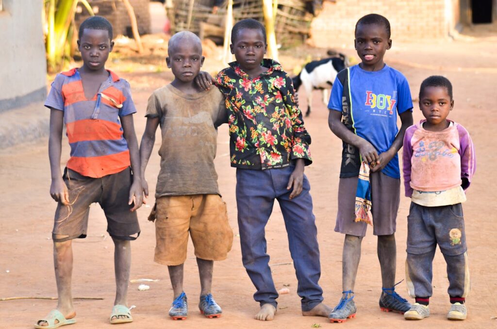 Five boys standing together outdoors in Lilongwe, Malawi. Casual and friendly.
